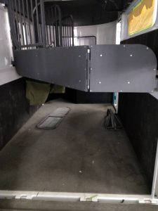 A horse trailer equipped with sturdy composite flooring boards designed to safely support and transport horses.