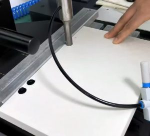 An image depicting the process of embedding nuts into PET foam board using an ultrasonic welding machine.