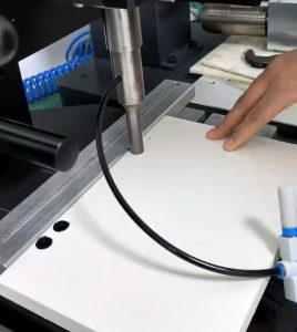 An image depicting the process of embedding nuts into PET foam board using an ultrasonic welding machine.